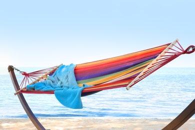 Photo of Colorful hammock with blanket at seaside. Summer vacation