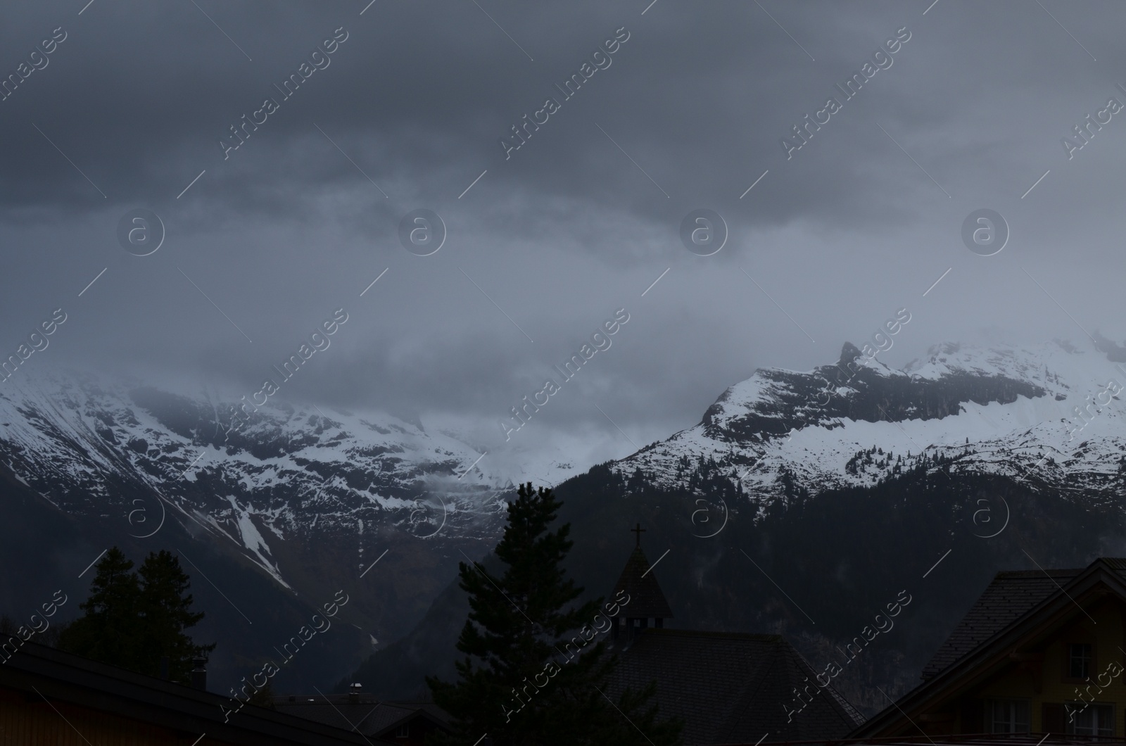 Photo of Picturesque view of cottage village and mountains covered with fog