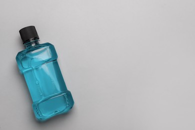 Photo of Mouthwash on light grey background, top view. Space for text