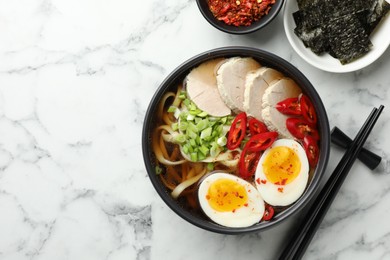 Photo of Delicious ramen in bowl served on white marble table, flat lay with space for text. Noodle soup