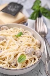 Photo of Delicious pasta with mushrooms and cheese in bowl on table, closeup