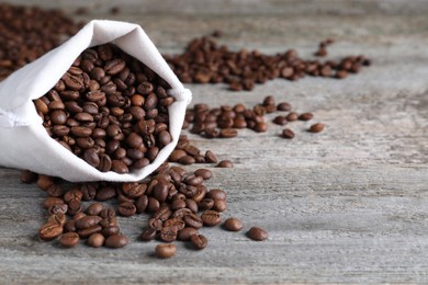 Photo of Bag of roasted coffee beans on wooden table. Space for text