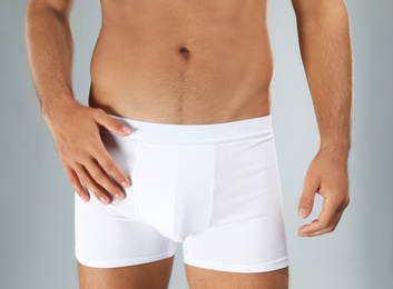 Photo of Man in white underwear on light grey background, closeup