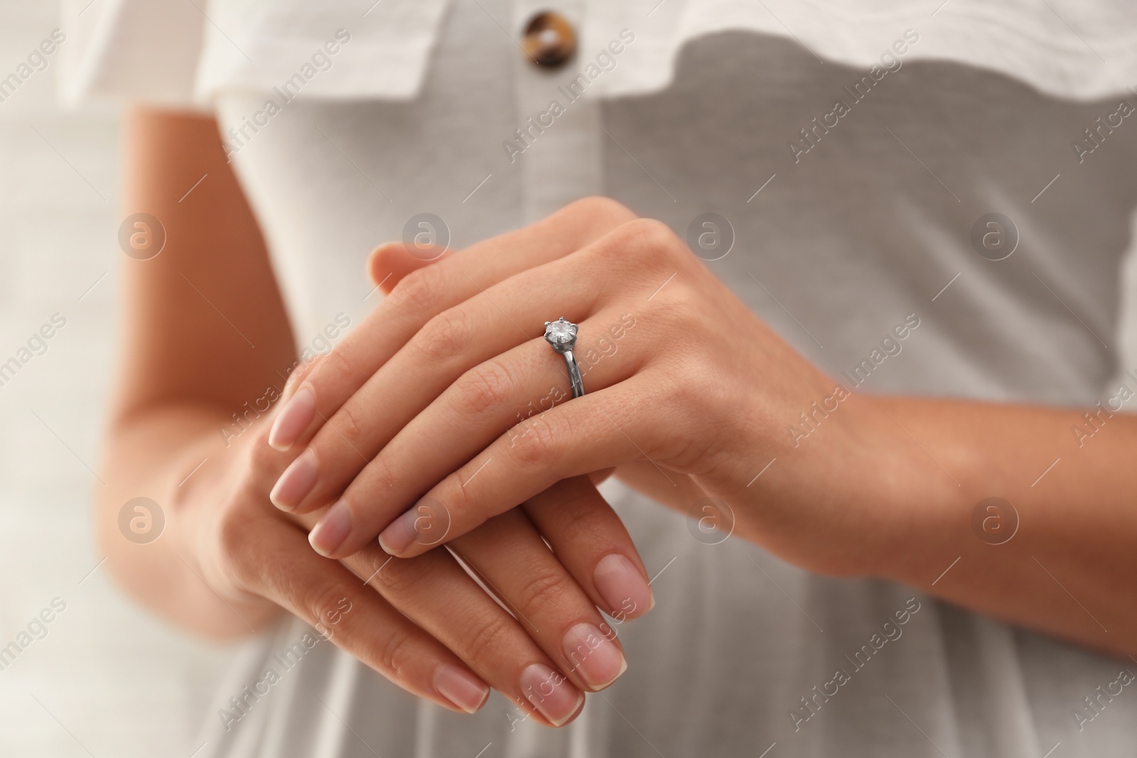 Photo of Young bride wearing beautiful engagement ring, closeup