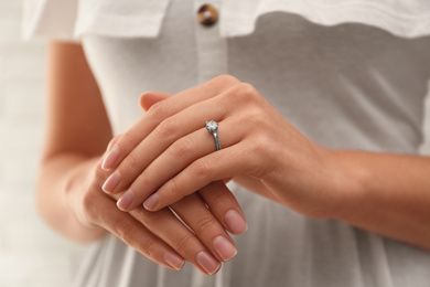 Photo of Young bride wearing beautiful engagement ring, closeup