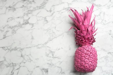 Photo of Pink pineapple on white marble background, top view with space for text. Creative concept