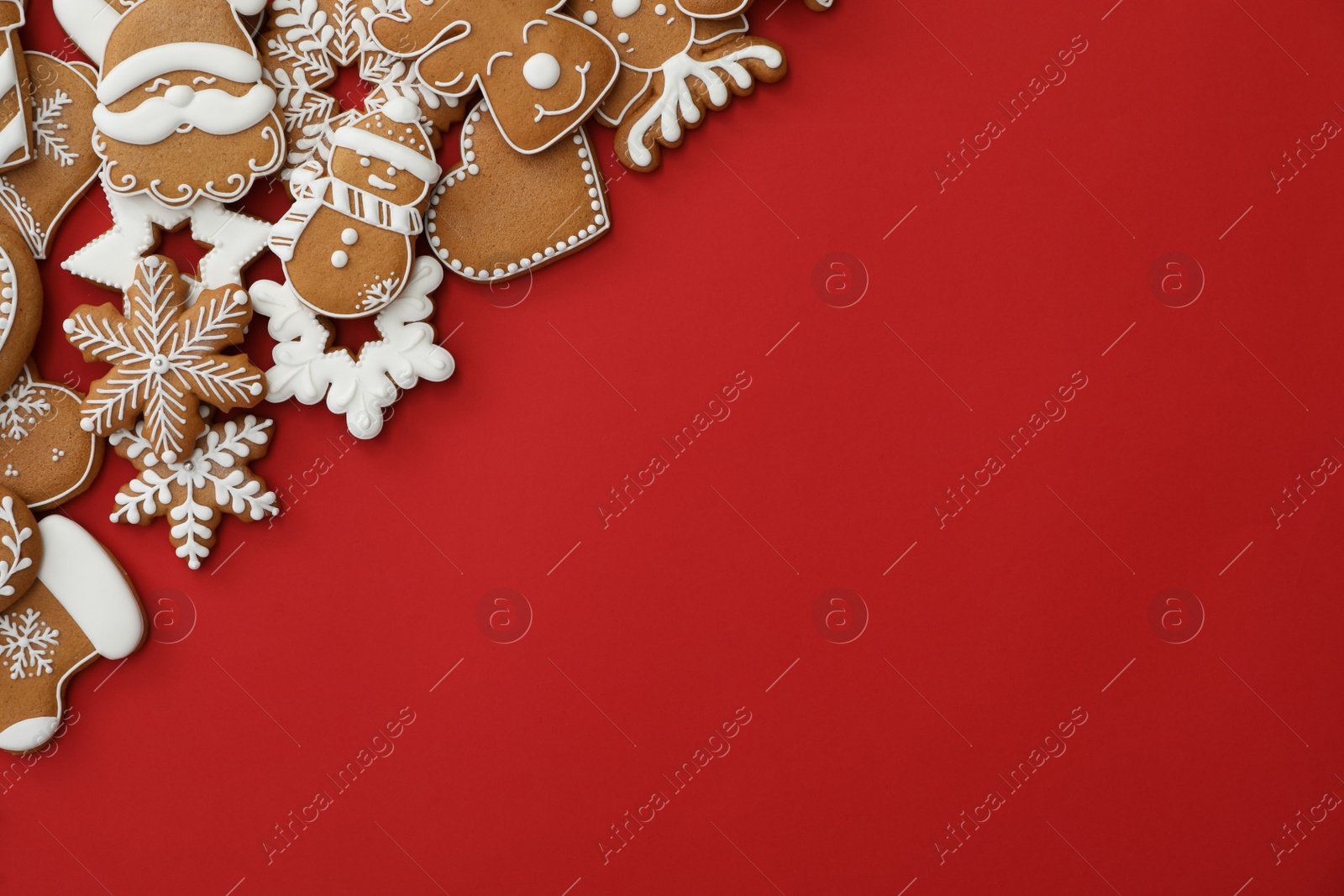 Photo of Different Christmas gingerbread cookies on red background, flat lay. Space for text