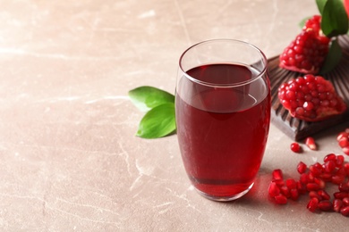 Photo of Composition with glass of fresh pomegranate juice on table. Space for text