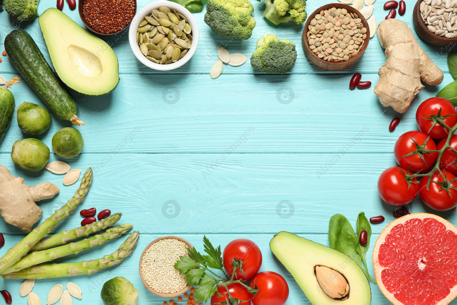 Photo of Frame of fresh vegetables, fruits and seeds on light blue wooden table, flat lay. Space for text