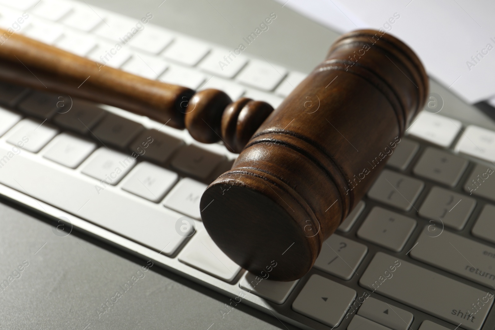 Photo of Gavel and computer keyboard on grey table. Cyber crime