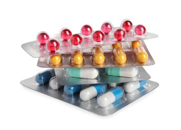 Photo of Stack of blisters with different pills on white background