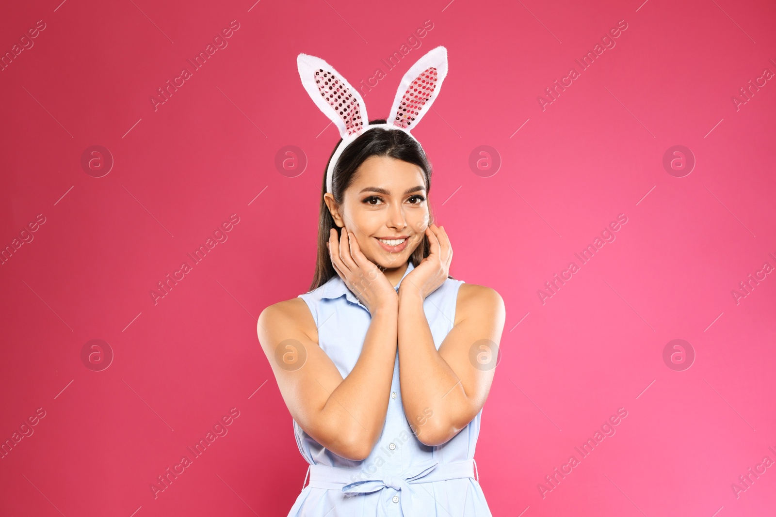 Photo of Portrait of beautiful woman in Easter bunny ears headband on color background