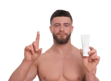 Handsome man with tube of body cream on white background