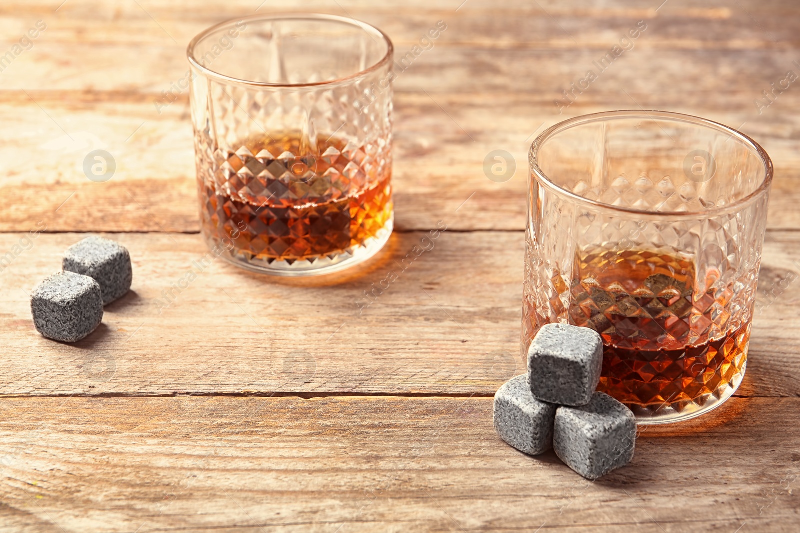Photo of Glasses with liquor and whiskey stones on table