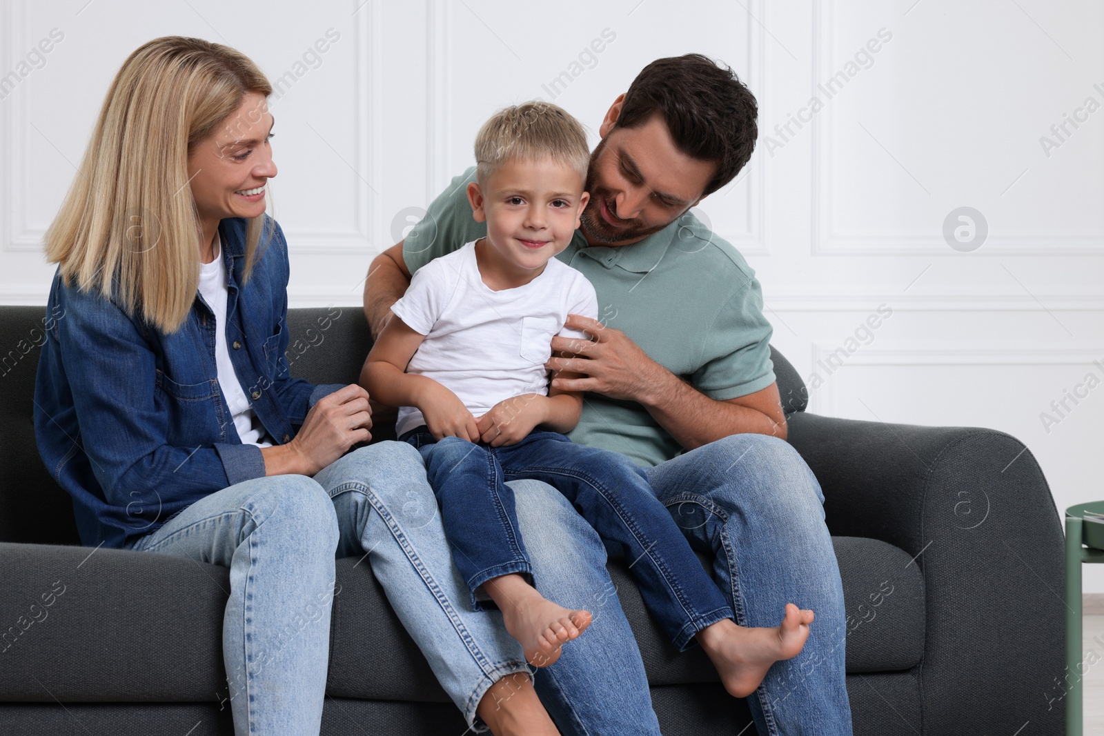 Photo of Happy family having fun together on sofa at home