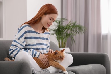 Photo of Woman with her cute cat on sofa at home