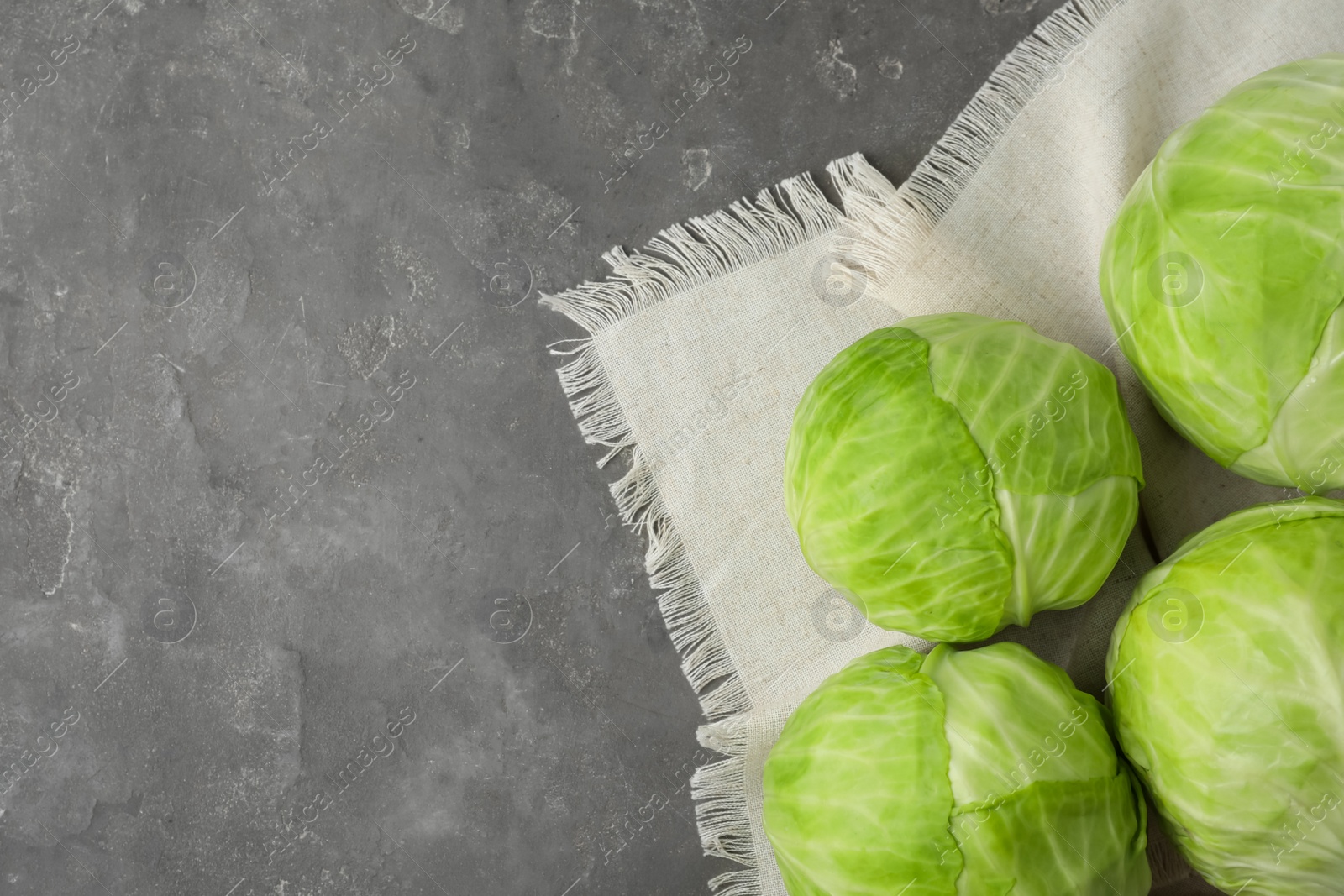 Photo of Ripe white cabbage on grey table, flat lay. Space for text