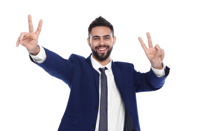 Photo of Happy young businessman showing victory gesture on white background