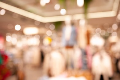 Photo of Blurred view of modern boutique interior with stylish clothes