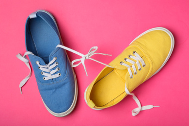 Photo of Shoes tied together on pink background, flat lay. April Fool's Day