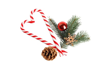Photo of Candy canes and Christmas decorations on white background, top view