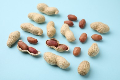 Fresh unpeeled peanuts on light blue table