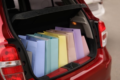 Photo of Shopping bags in car trunk outdoors, closeup