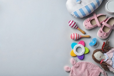 Flat lay composition with baby accessories and toys on gray background. Space for text