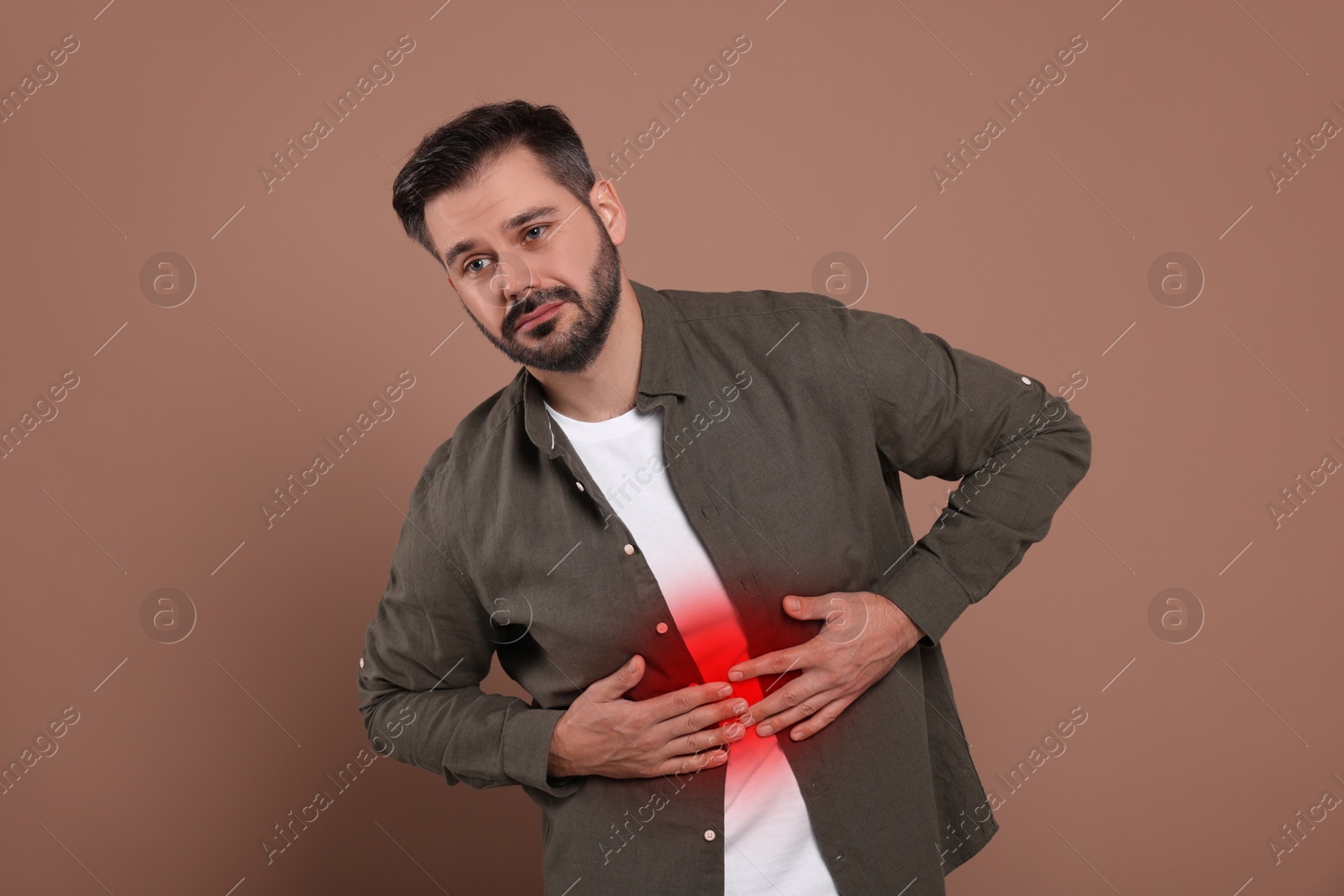 Image of Man suffering from abdominal pain on brown background