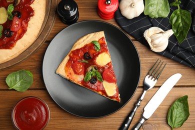 Photo of Slice of delicious pita pizza and ingredients on wooden table, flat lay
