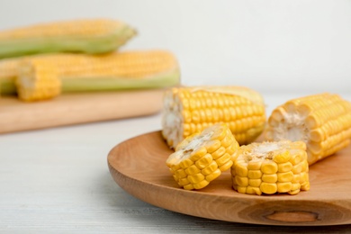 Photo of Plate with tasty sweet corn on wooden table