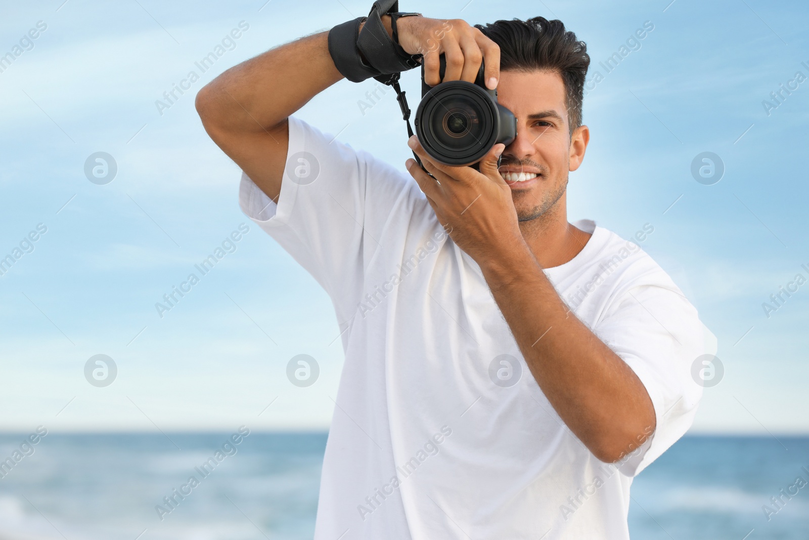 Photo of Photographer taking picture with professional camera near sea