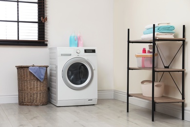 Modern washing machine in laundry room interior