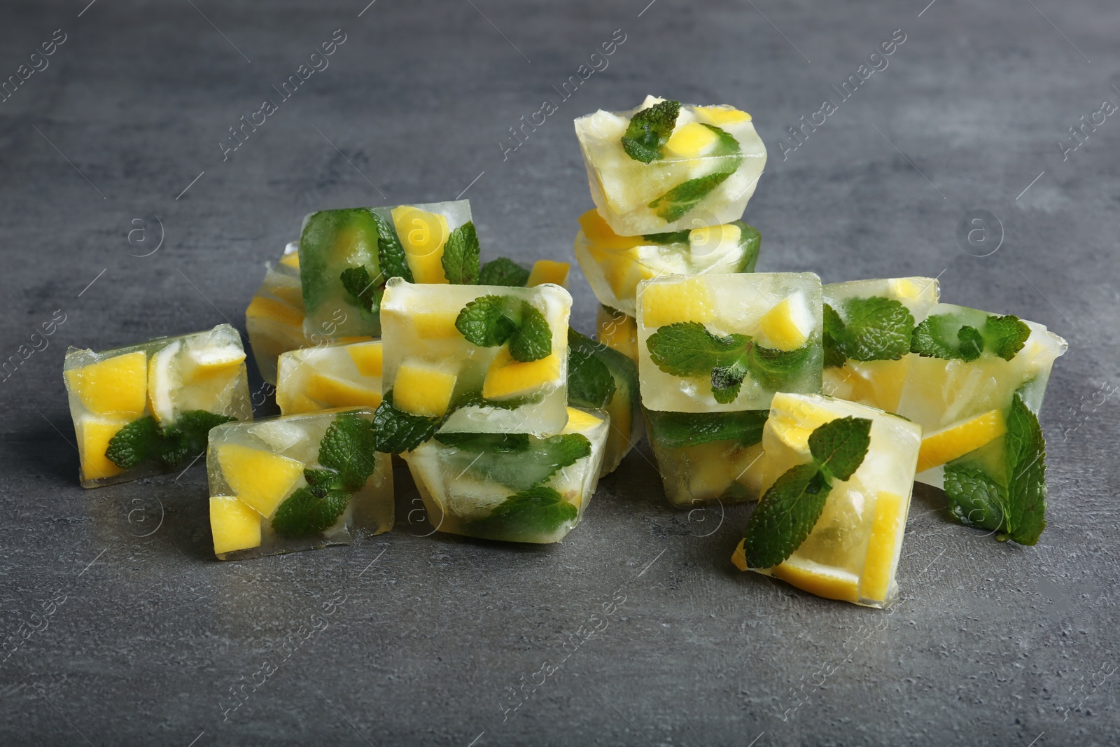 Photo of Ice cubes with mint and lemon on grey background