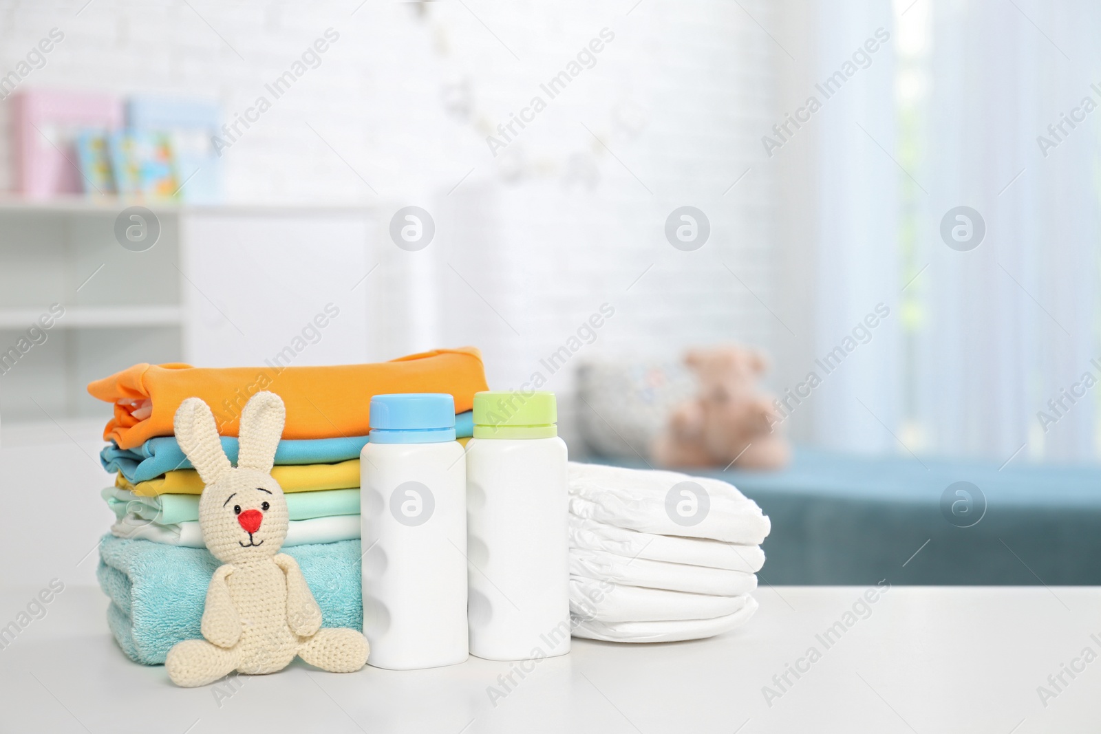 Photo of Baby accessories on table in nursery room. Space for text