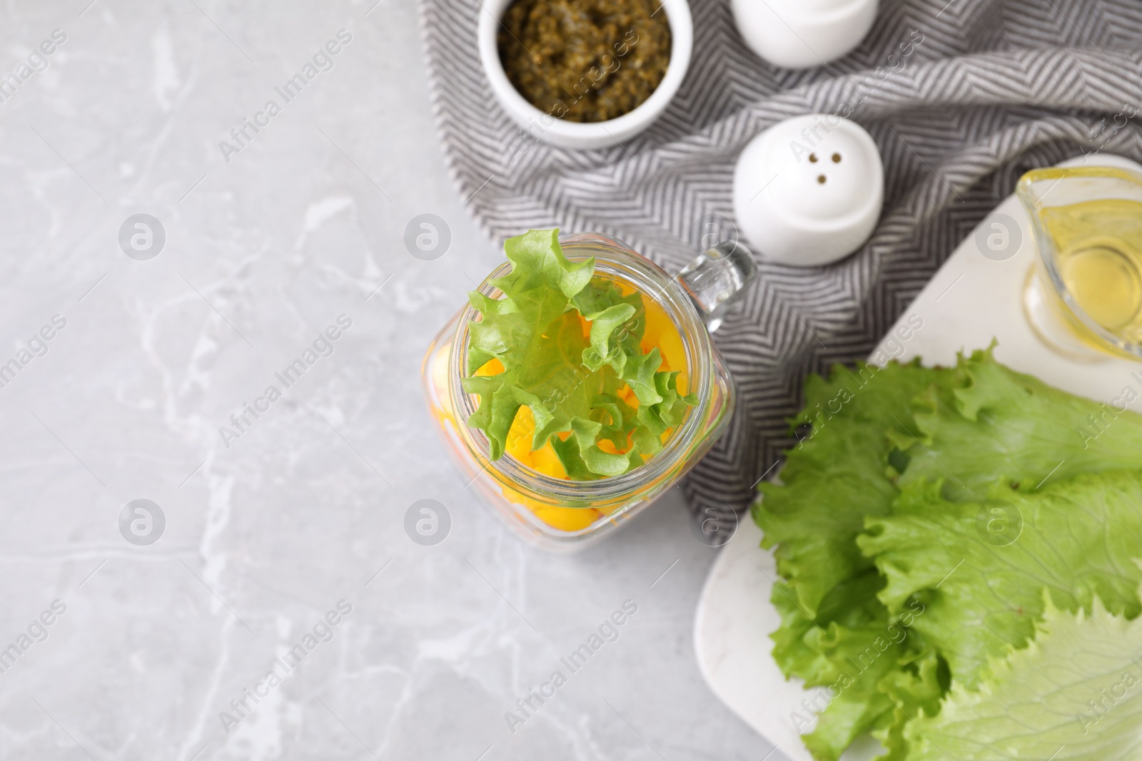 Photo of Healthy salad in glass jar on marble table, flat lay