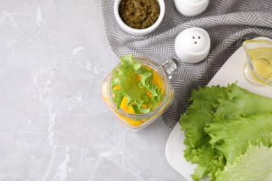 Photo of Healthy salad in glass jar on marble table, flat lay