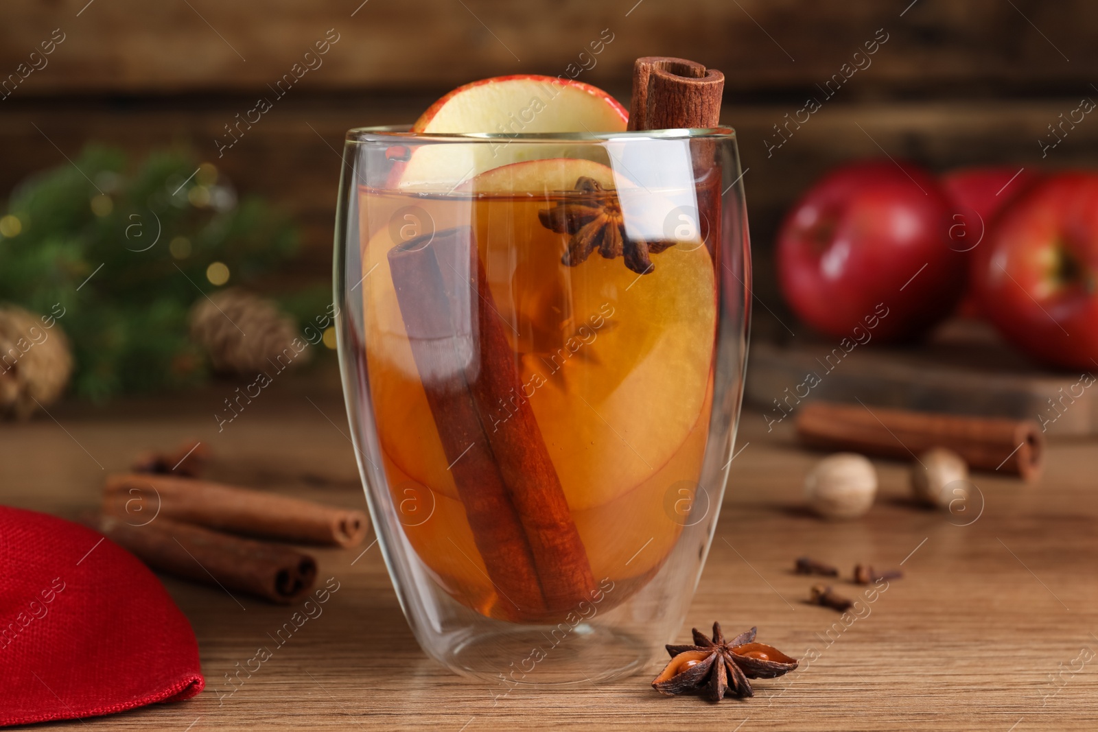 Photo of Hot mulled cider on wooden table, closeup