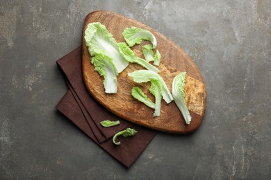 Photo of Pieces of fresh Chinese cabbage on gray textured table, top view