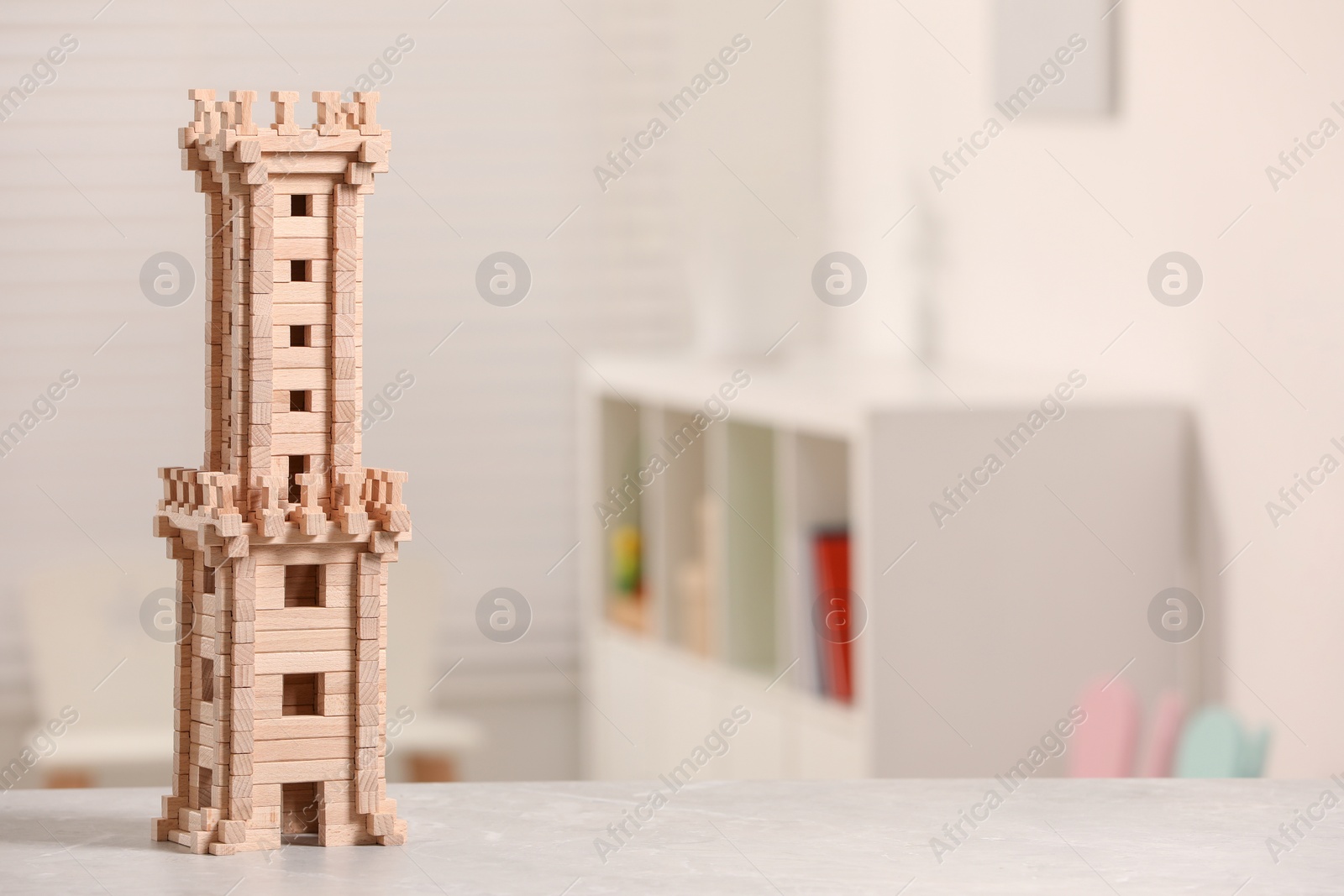 Photo of Wooden tower on table indoors, closeup. Space for text. Children's toy