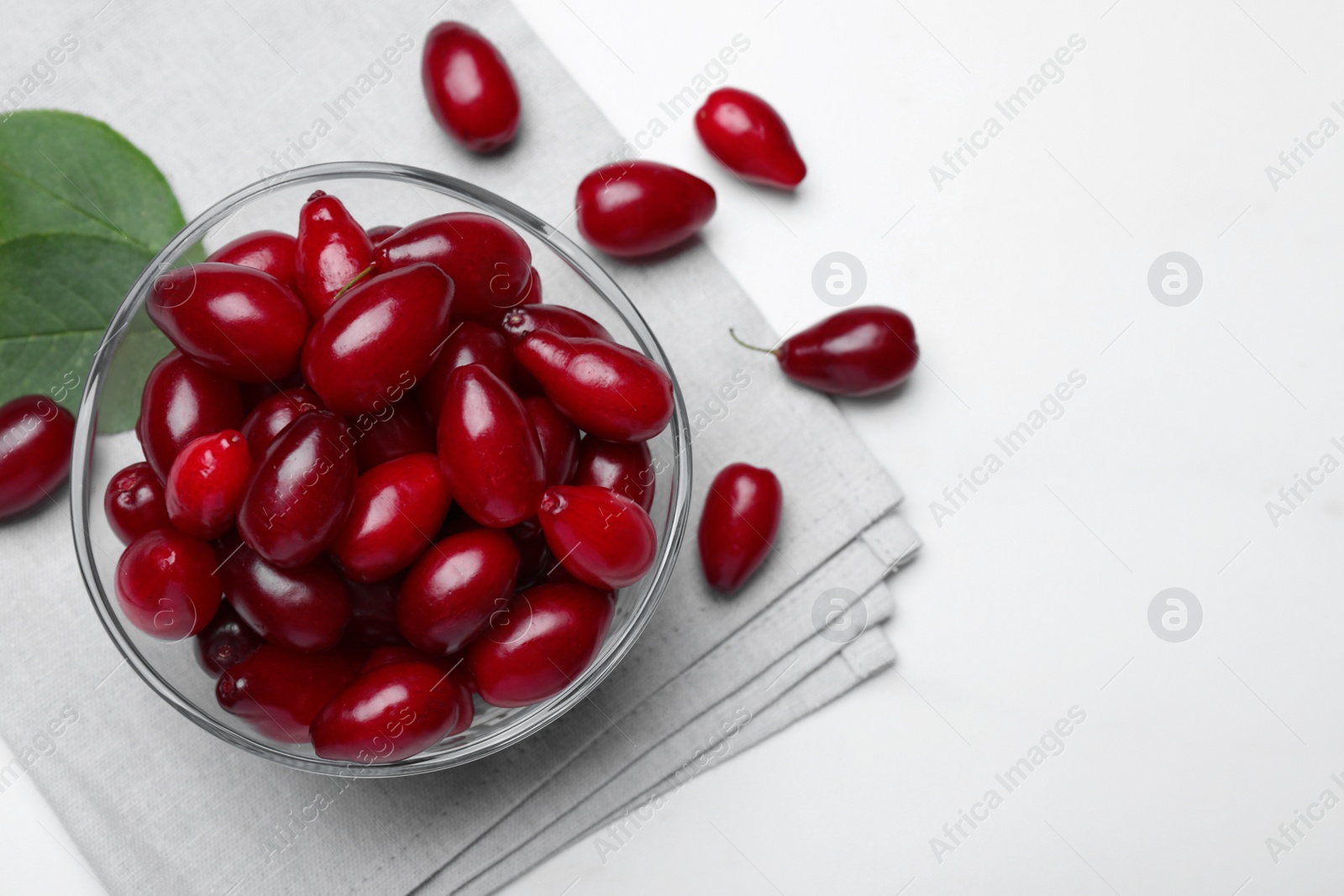 Photo of Fresh ripe dogwood berries on white table, flat lay. Space for text