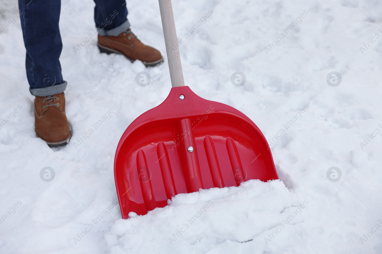 Photo of Man removing snow with shovel outdoors, closeup