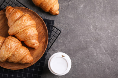 Photo of Fresh croissants and drink on grey table, flat lay. Space for text