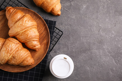 Fresh croissants and drink on grey table, flat lay. Space for text