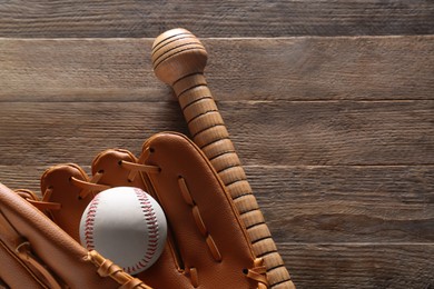 Photo of Baseball glove, bat and ball on wooden table, flat lay. Space for text
