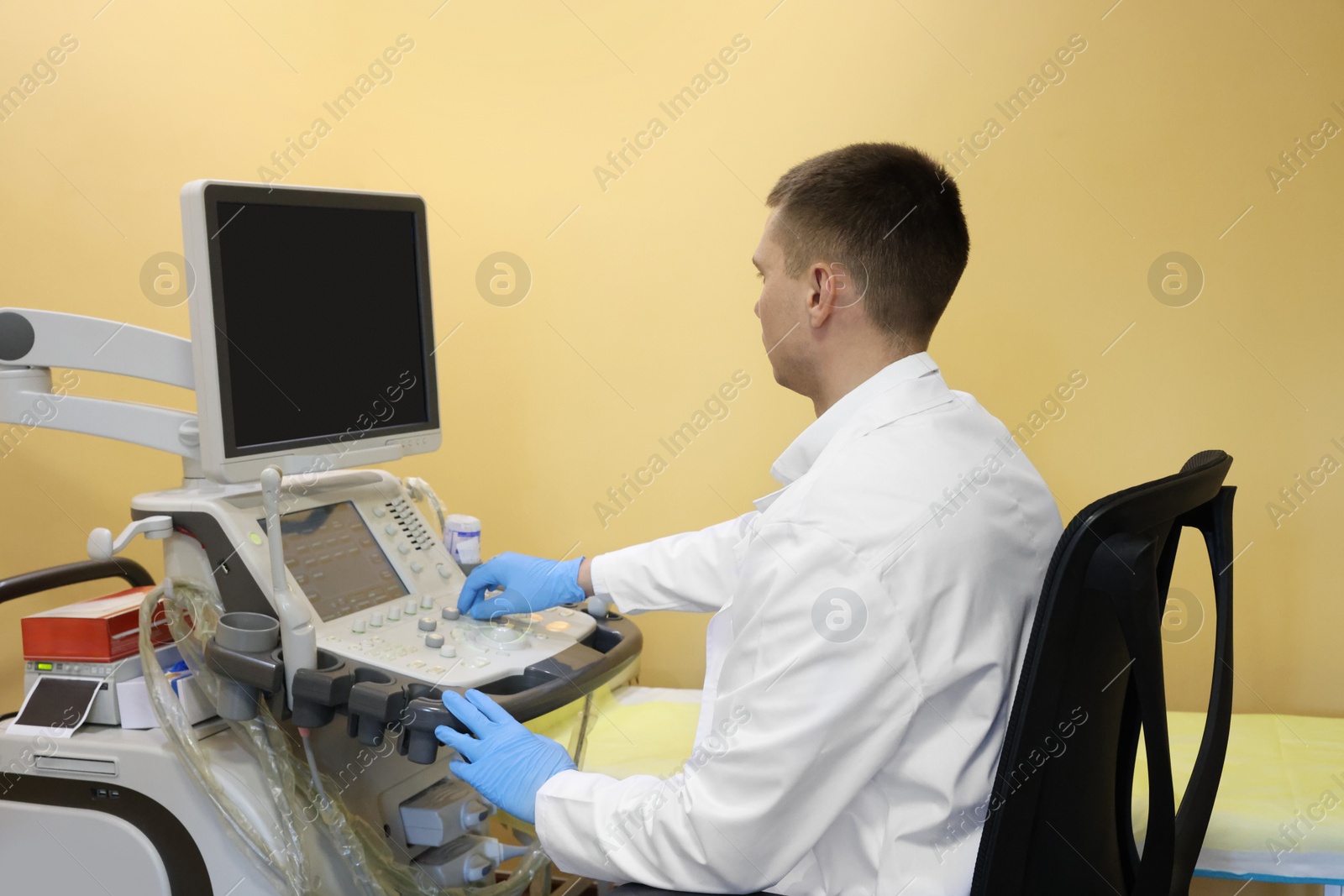 Photo of Doctor working with ultrasound machine in clinic