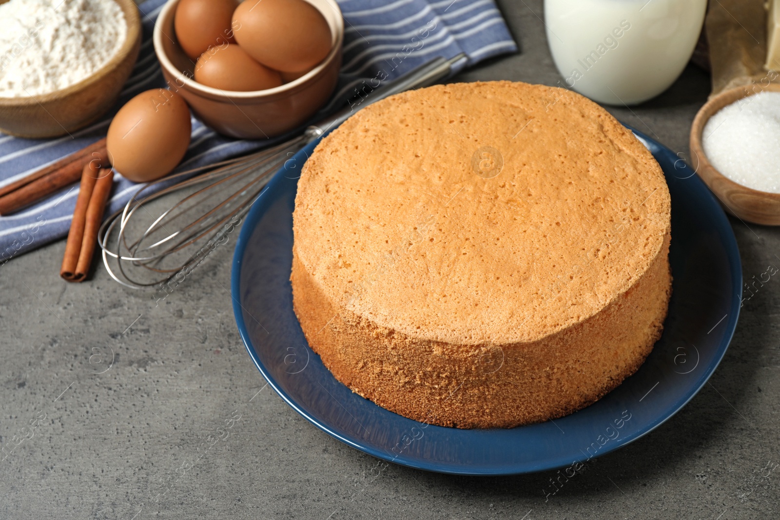 Photo of Delicious fresh homemade cake and ingredients on grey marble table