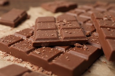 Pieces and crumbs of tasty chocolate bars on table, closeup