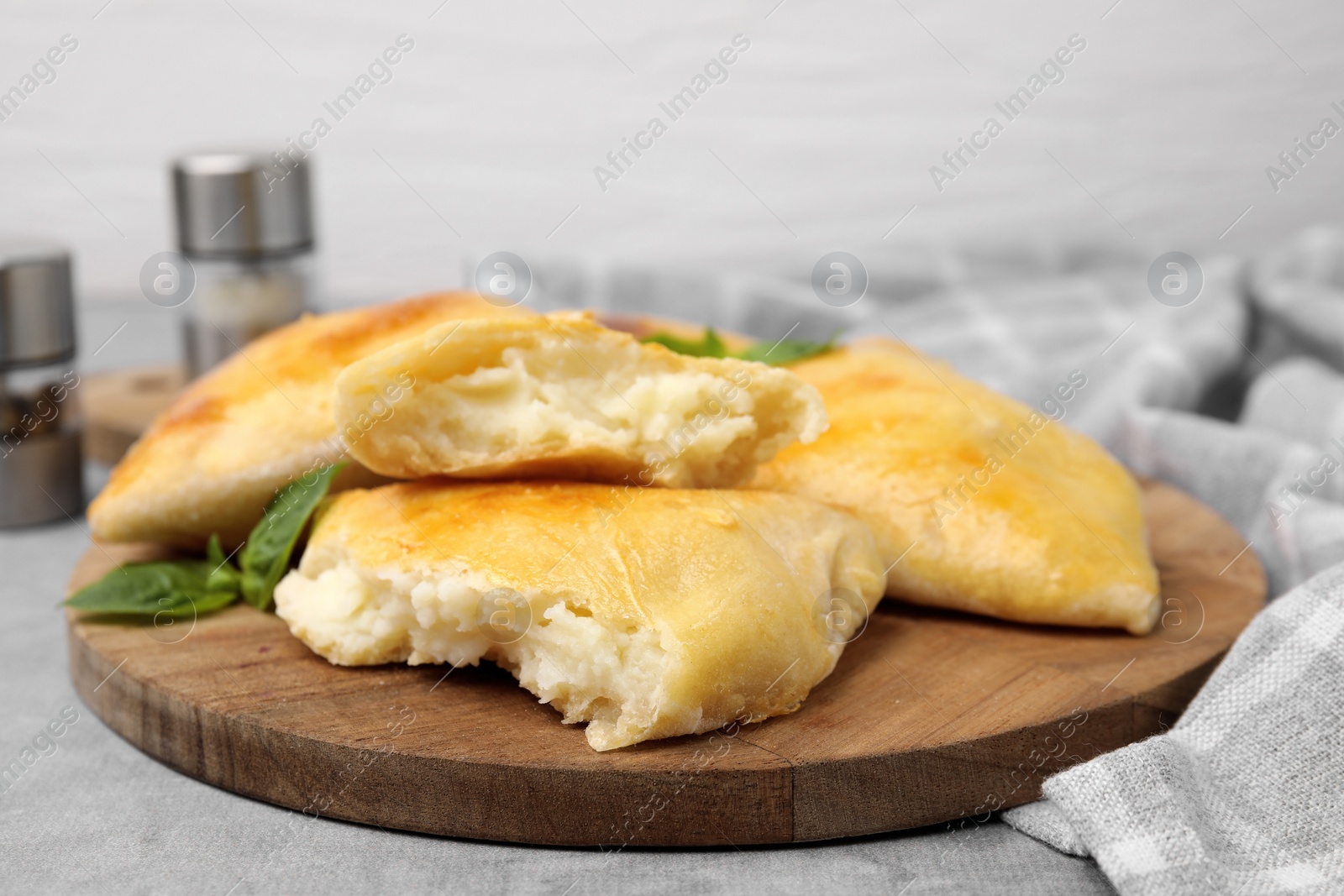 Photo of Delicious samosas and basil on grey table