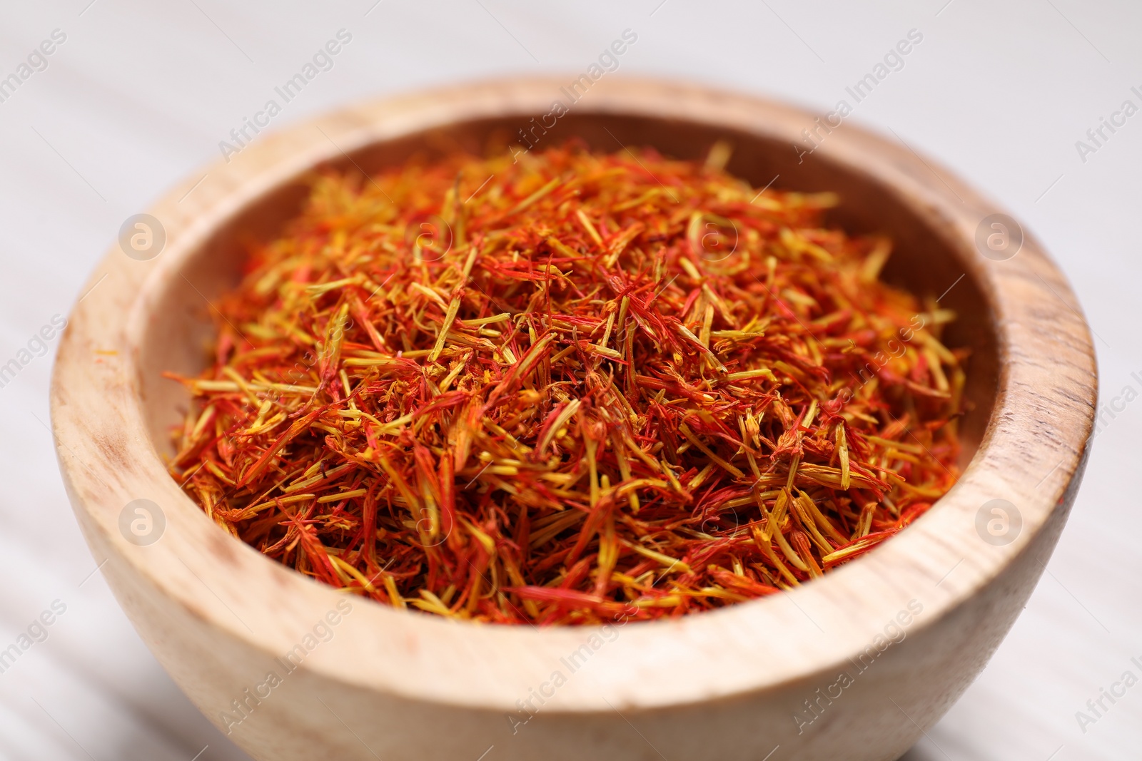 Photo of Aromatic saffron in bowl on table, closeup